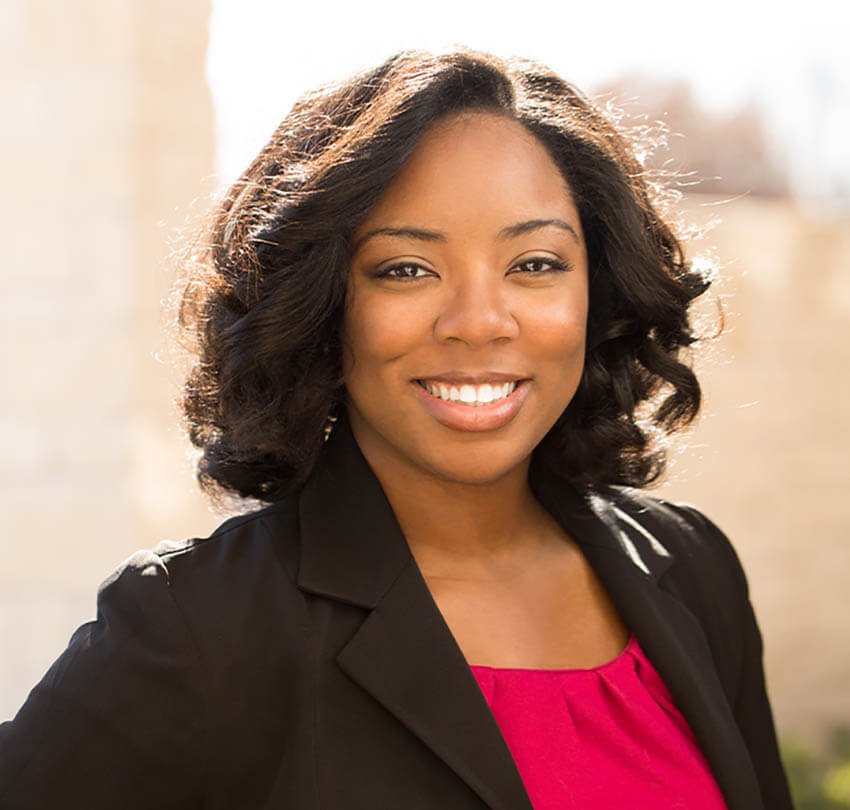 Smiling woman in professional attire, showcasing a confident smile, representing the benefits of cosmetic dentistry and enhanced self-esteem.
