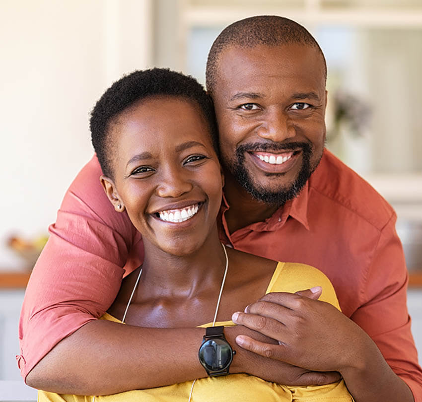 Smiling couple showcasing healthy, attractive teeth, representing the benefits of dental implants and oral health at Biodental Health and Longevity.