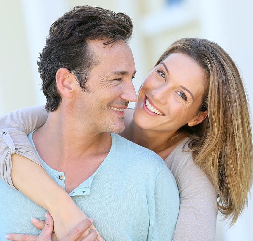 Happy couple smiling together, representing health and longevity, embodying wellness and vitality in the context of Biodental Health and Longevity services.