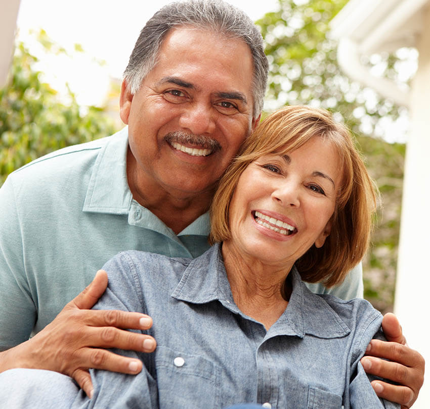 Happy older couple smiling together, showcasing healthy smiles, representing the benefits of metal-free dentistry and biocompatible care at Biodental Health and Longevity.