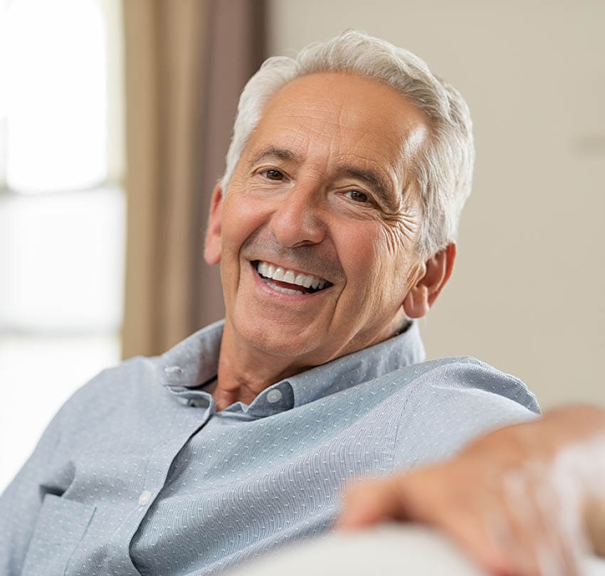 Smiling older man with a healthy smile, representing the benefits of restorative dentistry and patient satisfaction at Biodental Health and Longevity in Pensacola.