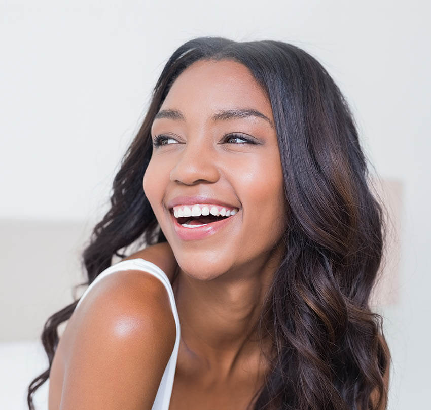Smiling woman with radiant white teeth showcasing the benefits of professional at-home teeth whitening services by Biodental Health and Longevity.